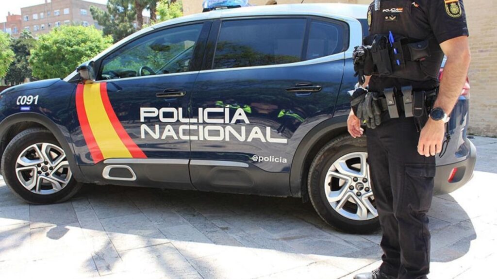 Una persona en frente de un coche.