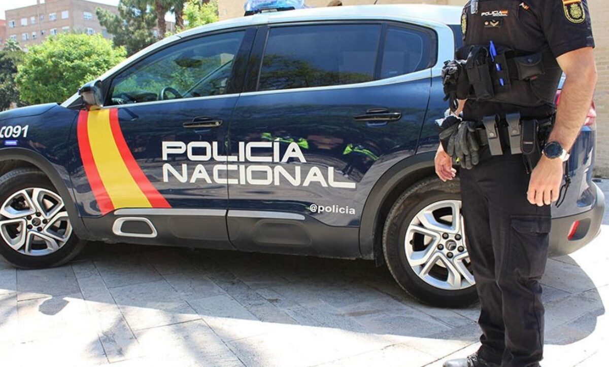 Una persona en frente de un coche.