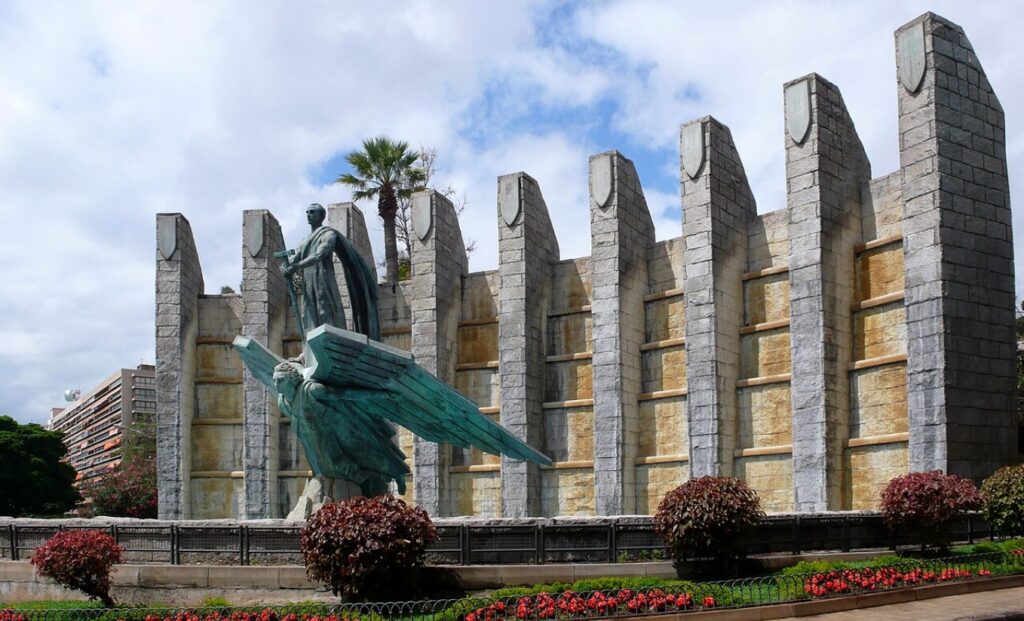 Estatua de una persona en frente de un edificio.